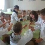 eksperyment chemiczny dzieci w fartuszkach